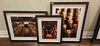 Front view of three framed prints standing side by side