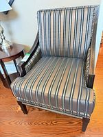 Front angled view of the striped armchair showing wood frame and cushion