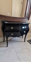 Front view of black bombe console table with two drawers