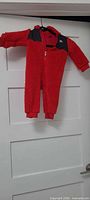 Full view of red sherpa Nike hooded onesie hanging