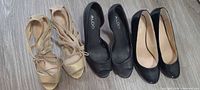 All three pairs side by side: gold sandals, black peep-toe, black patent wedge