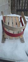 Top view of wood slat toboggan showing curved side rails and red paint