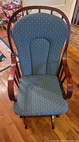 Front view of glider rocking chair showing full frame and cushions
