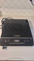 Top view of Salton induction cooktop showing surface, controls and cord
