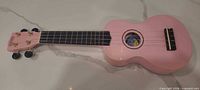 Full view of pink Mahalo ukulele showing body, neck and overall condition