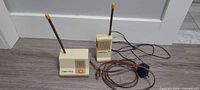 Two Fisher-Price baby monitor units with cords and antennas