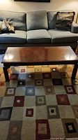 Rectangular cherry wood coffee table in front of sofa