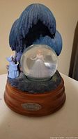 Front view of Cinderella snow globe showing globe, Fairy Godmother, tree, wood base and plaque