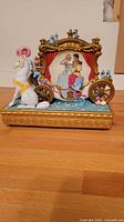 Front view of Disney snow globe carriage with horse and figures inside