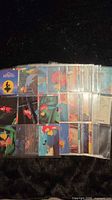 Stack of plastic pages filled with Little Mermaid trading cards