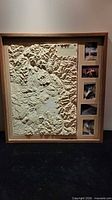 Front view of framed embossed relief map with photo panels