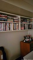 Wide view of both shelves filled with DVDs and some VHS tapes
