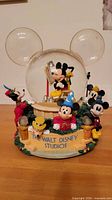 Front view showing Disney snow globe with characters and The Walt Disney Studios plaque