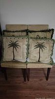 Front view of four pillows showing two single-palm and two clustered-palm designs