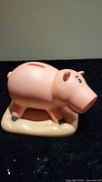 Front-left view of Hamm piggy bank on beige base