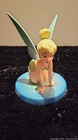 Front view of kneeling Tinker Bell figurine on blue base