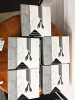 Front view of five boxed ATIVA floor cord organizers on table