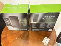 Retail boxes for Insignia 2-way indoor/outdoor speakers showing specifications and branding