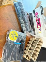 Swingline laminator (in plastic) with DirecTV receiver, power cable and packaging materials on table