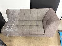 Full view of taupe left-arm chaise showing tufted upholstery and chrome legs