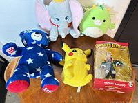Group shot of all four plush toys and boxed figure