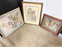 All three framed prints leaning against wall