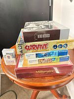 Stack of sealed board games, puzzles, and sleeve pack on table