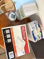 Overall lot showing NuTone 763N box, Broan kit box, four white LED light cartons, round accessory