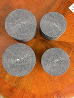 Top view of four round grey shagreen-style boxes