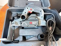 Planer in carrying case with dust bag, power cord and accessories visible