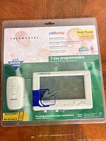 Front of sealed retail package showing thermostat and remote