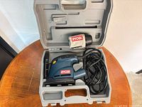 Detail sander, cord, dust bag, and case overview