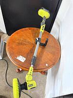 Full view of scrubber with telescoping shaft, auxiliary handle and battery attached