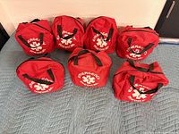 Front view of seven red emergency medical pouches showing Star of Life emblems
