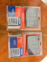 Front view of two sealed remote control panels showing model and branding