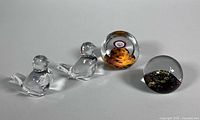 Group shot: two crystal birds, Selkirk paperweight, gold-fleck paperweight