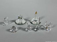 Group shot showing all seven figurines and two mirrored bases