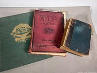 Three hardcover books laid out: red 1926 atlas, green 1972 York County atlas reprint, blue 1909 Book of Facts