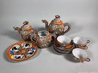 Overall lot showing teapot, creamer, sugar bowl, teacups, saucers and Geisha Girl plate