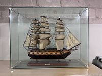 Model tall ship inside glass case, full view