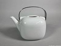 Front view of white porcelain teapot with stainless steel handle
