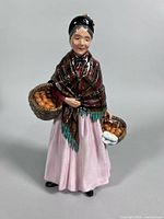 Front view of figurine showing full attire and baskets