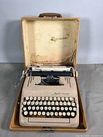 Typewriter seated inside open hard case