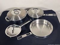 All four stainless steel cookware pieces with lids displayed