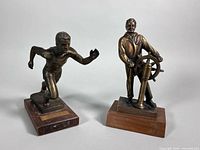 Front view of both brass statues on wooden bases