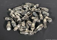 Pile of assorted glass vacuum tubes on black background