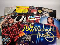 Pile of all records showing covers including Foreigner, Spinners, Saturday Night Fever, Grease, Stars, Midnight Hustle, Pure Power, Blues Magoos, Ramsey Lewis, Andy Gibb