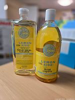 Front view of both unopened Lemon Aide bottles