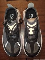 Top view of both shoes showing tag, laces, reflective details, Norda × Dyneema insoles