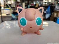 Front view of Jigglypuff vinyl figure showing eyes, tuft and limbs